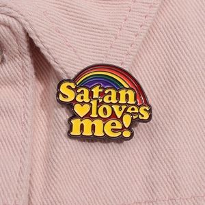 Detailansicht der Regenbogen-Emaille-Anstecknadel mit Satan loves me Text auf Jeans
