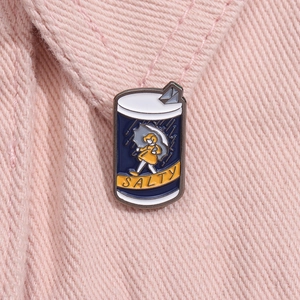 Detailed view of an enamel pin featuring a girl with an umbrella and SALTY text on a pink jacket