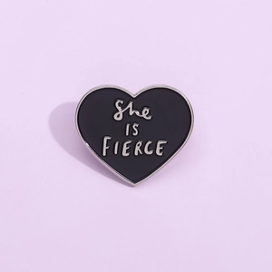 Fierce heart-shaped black enamel brooch with silver metal edge and empowering slogan