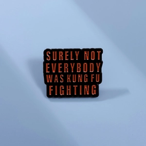 Detail einer quadratischen Emaille-Anstecknadel mit Kung-Fu-Spruch auf blauem Grund