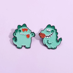 Détail macro de deux broches dinosaures en émail vert sur un fond violet clair