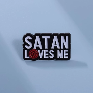Macro shot of Satan Loves Me enamel pin with pentagram detail on alloy metal badge