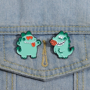 Gros plan de pin's dinosaures mignons en émail sur une poche de veste en jean bleu