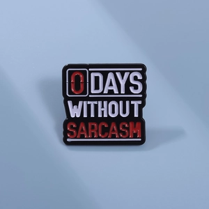 Detailed view of enamel pin with humor text 0 DAYS WITHOUT SARCASM in black and red