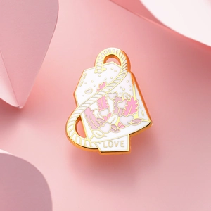 Kreative Teebeutel Emaille Pin mit rosa Herzblatt und LOVE Anhänger auf rosa Papier