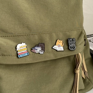 Cute cartoon cat and books enamel lapel pins set on green canvas backpack flap