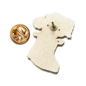 Detail showing the textured metal back of the flower brooch with a gold butterfly clutch