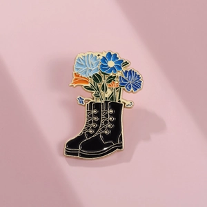 Creative black leather boot brooch with blue enamel flowers and golden metal trim
