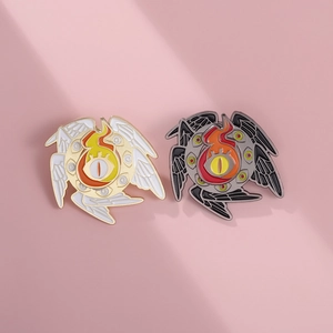 Detailed macro view of black and white Eye of Horus enamel pins with flame wing design