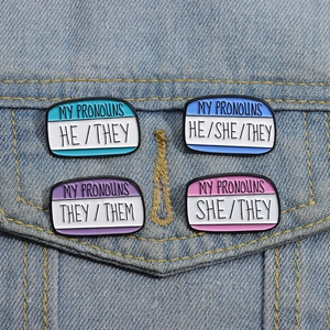 Pronoun enamel pins on denim jacket featuring he/she/they gender identity designs