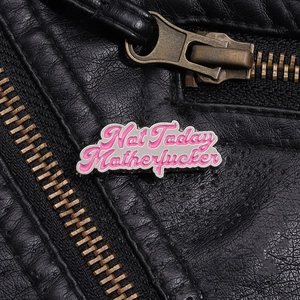 Makro-Detail des rosa Not Today Emaille-Pin auf einer schwarzen Lederjacke mit Reißverschluss
