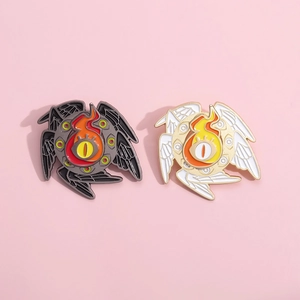 Detailed close-up of Eye of Horus enamel pins with intricate wings on pink background