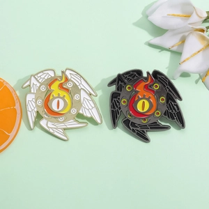 Detail view of fantasy Eye of Horus enamel pins with wings and flames on green background