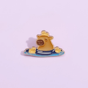Cute capybara enamel pin with yellow ducks in blue water pool on a purple background