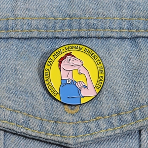Pin's en émail jaune avec un motif de dinosaure sur une veste en jean bleue