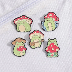 Set of 5 cute enamel pins featuring frogs with mushrooms and banjos on canvas