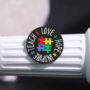 Macro detail of enamel pin with colorful puzzle design and Love Hope Inspire text