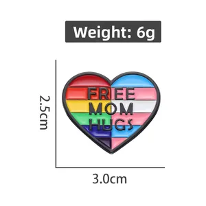 Dettaglio della spilla a cuore arcobaleno con scritta Free Mom Hugs e misure del prodotto
