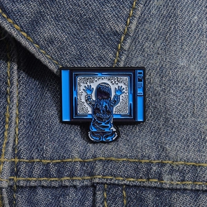 Detail of vintage TV enamel pin with long hair girl silhouette on denim jacket