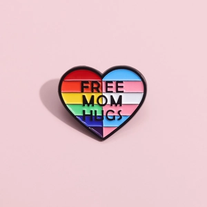 Vista dettagliata della spilla a cuore Pride con scritta Free Mom Hugs su sfondo rosa