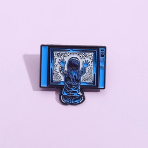 Creative enamel pin featuring a retro TV with a girl character on a lilac background