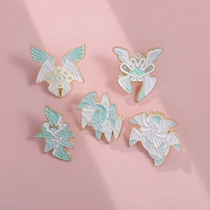 Vue détaillée de cinq épinglettes émaillées avec ailes d'ange et yeux sur fond rose