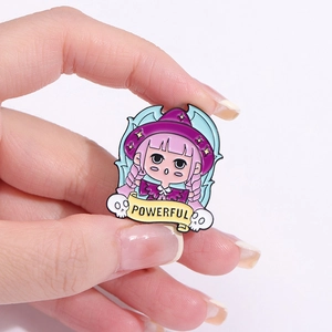 Macro detail of enamel witch pin with purple hat and yellow banner reading POWERFUL
