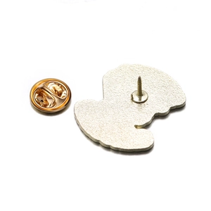 Detail of metal enamel brooch back featuring textured finish and gold butterfly clutch
