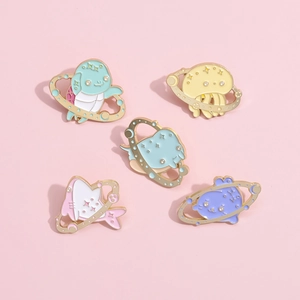 Detailed view of five enamel pins with cosmic sea animal designs and golden metal edges