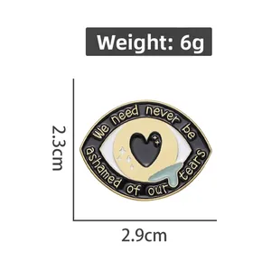 Détail de la broche en émail œil avec dimensions 2,3 cm x 2,9 cm et poids de 6 g
