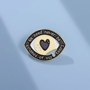 Broche en émail en forme d'œil avec motifs cœur et étoile et texte de motivation