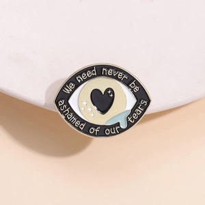 Broche en émail œil de cœur doré avec citation inspirante et détail de larme bleue