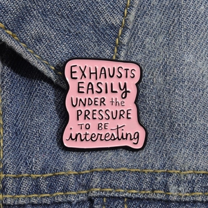 Pink enamel brooch pin with quote on blue denim jacket, vintage style metal badge