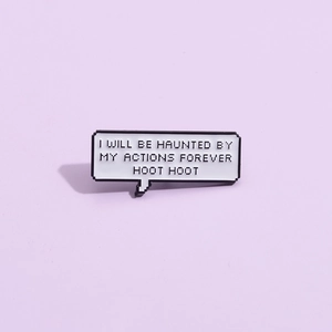 Macro view of pixel art enamel pin with I WILL BE HAUNTED BY MY ACTIONS FOREVER text