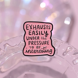 Pink enamel quote brooch with creative lettering on an artistic glass background