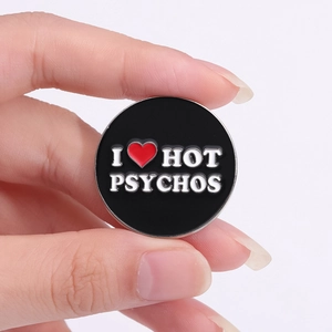 Badge en émail noir avec texte I Heart Hot Psychos tenu à la main pour vêtements et sacs