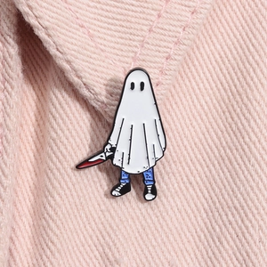 Détail macro d'une épingle fantôme en émail blanc avec couteau sur tissu rose