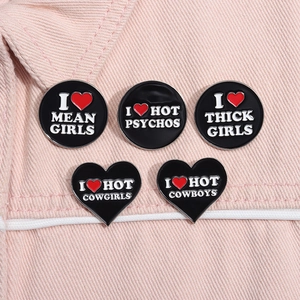 Vue détaillée de 5 broches en émail noir avec cœurs rouges sur denim rose