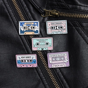 Set of five colorful retro cassette tape enamel pins on a black leather jacket background