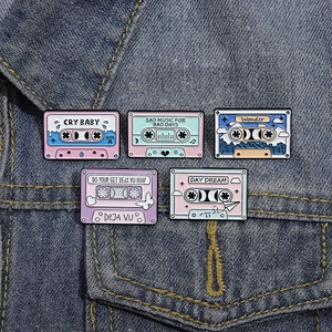 Retro colorful cassette tape enamel pins set on blue denim jacket fabric