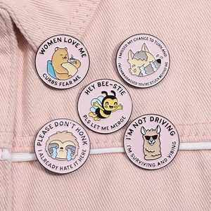Detailed macro shot of 5 cute enamel pins with funny animals on pink denim background