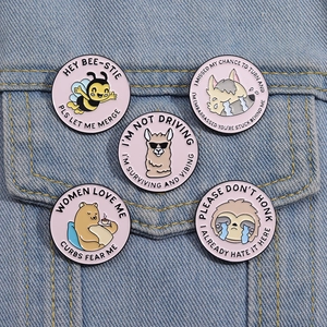 Set of five pink cartoon enamel pins with bee and sloth designs on denim jacket