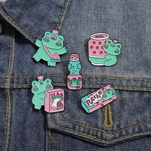 Détails macro de cinq pins émaillés de grenouilles sur denim montrant l'artisanat