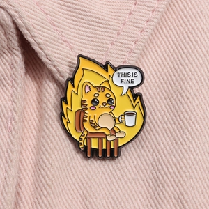 Detailed close-up of a cartoon cat This Is Fine enamel pin on pink corduroy fabric