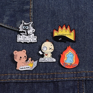 Macro view of five enamel pins with humorous cat and dog designs on denim fabric