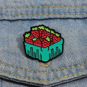 Détail de la broche émaillée panier de fraises sur denim bleu aux couleurs vives