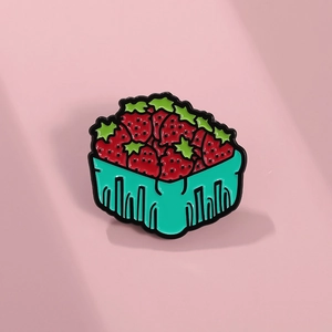 Détail du pin's en émail panier de fraises avec baies rouges et feuilles vertes sur rose