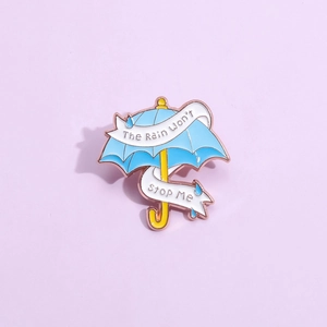 Makroaufnahme der blauen Emaille-Regenschirm-Anstecknadel mit inspirierendem Text