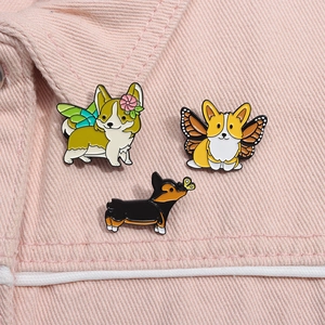 Vue détaillée de trois épingles en émail corgi sur un col de veste en jean rose