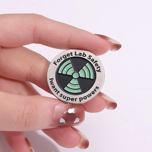 Enamel science pin with radioactive symbol and 'I want super powers' quote
